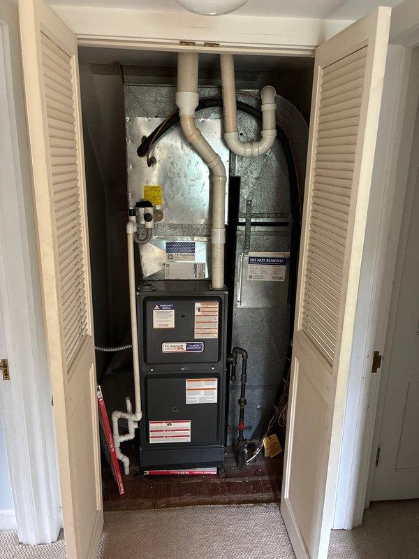 Conducted on-site evaluation of existing forced air HVAC system for complete air conditioning replacement. Assessed current equipment configuration housed in interior utility closet, including dark gray furnace unit with connected air handler cabinet and associated PVC condensate drainage and ventilation piping. Documented existing system layout, ductwork connections, and installation specifications. Presented comprehensive replacement options for upgraded AC system compatible with current forced air infrastructure and closet-mounted configuration.