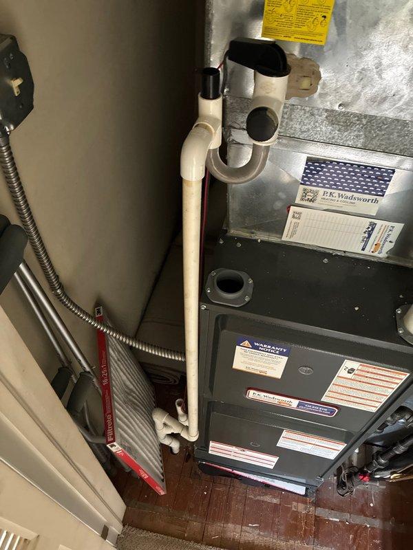 Conducted on-site evaluation of existing forced air HVAC system for complete air conditioning replacement. Assessed current equipment configuration housed in interior utility closet, including dark gray furnace unit with connected air handler cabinet and associated PVC condensate drainage and ventilation piping. Documented existing system layout, ductwork connections, and installation specifications. Presented comprehensive replacement options for upgraded AC system compatible with current forced air infrastructure and closet-mounted configuration.