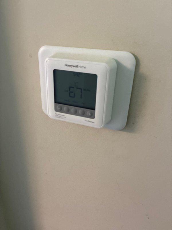 Conducted on-site assessment for furnace replacement options at residential property. Evaluated existing HVAC system including outdoor condensing unit and indoor climate control equipment. Documented current system configuration with exterior AC unit positioned on concrete pad with proper refrigerant line routing along foundation, and interior Honeywell programmable thermostat. Provided homeowner with comprehensive replacement options and recommendations for new furnace installation to improve heating efficiency and system performance.