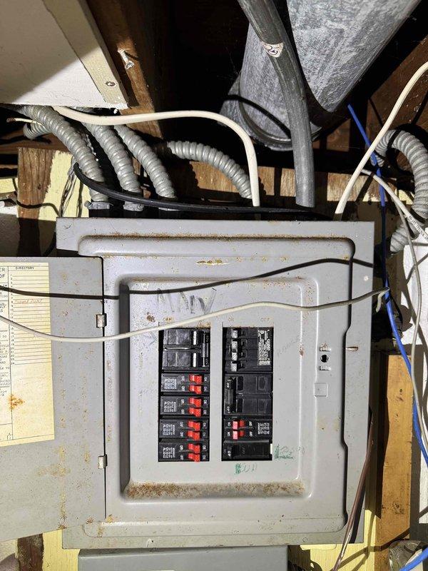 Responded to no cooling complaint on 15+ year old central air conditioning system. Upon inspection, discovered significant condensation on supply ductwork and air handler components, indicating possible airflow restriction or refrigerant issue. Observed moisture accumulation on metal surfaces throughout the system, suggesting the unit was attempting to operate but not achieving adequate cooling capacity. Inspected electrical panel serving HVAC equipment, noting aging infrastructure with signs of oxidation and dust accumulation on breaker connections. Documented system condition with photos showing condensation patterns on ductwork and overall electrical service configuration. Advised customer of equipment age and declining performance, recommending full system evaluation to determine whether repair or replacement would be most cost-effective solution given the unit's age exceeding manufacturer's typical service life expectancy.