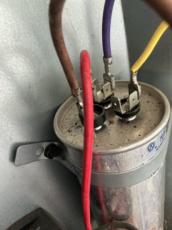 Performed comprehensive cooling maintenance on outdoor HVAC unit, including electrical diagnostics with multimeter readings showing 138.1 amperage, capacitor inspection with verification of all wire connections (brown, red, purple, and yellow leads), and visual assessment of equipment condition. All components found operating within normal parameters; unit returned to service.