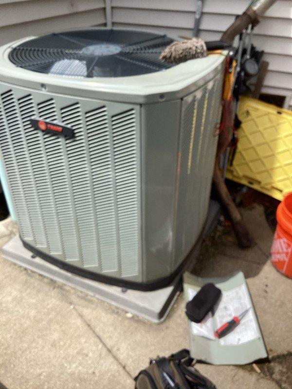 Completed cooling season tune-up on Trane outdoor condensing unit. Performed standard maintenance procedures including electrical diagnostics with multimeter readings, system performance verification, and visual inspection of refrigerant lines and cabinet condition. Unit operational with notable exterior rust staining observed on cabinet panels requiring future monitoring.