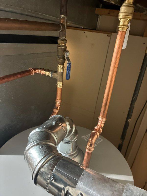 Returned to property to complete installation of 50-gallon hot water heater with required code upgrades. Installed new water heater unit with proper copper piping connections, brass fittings, and compression joints throughout the system. Added circulator pump assembly with appropriate shut-off valves including blue-handled ball valve for system isolation and maintenance access. All connections secured with code-compliant materials and proper support. System tested for leaks and proper operation upon completion.