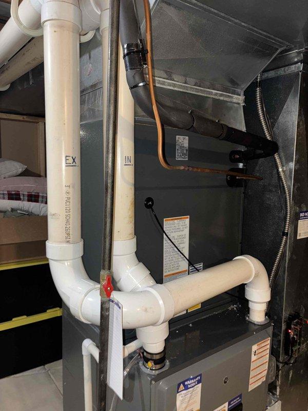 Completed installation of new air conditioning system including outdoor condensing unit and indoor evaporator coil. Performed system commissioning with differential pressure testing across ductwork to verify proper airflow, measuring static pressures at 0.12 and 0.04 inches water column. Integrated new refrigerant lines with existing furnace and ductwork infrastructure, ensuring proper connection to PVC intake and exhaust venting system. All components tested and operational upon completion.