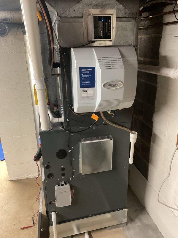 # HVAC Cooling Maintenance Summary

Completed scheduled preventive maintenance service on residential split-system air conditioning unit as part of ongoing maintenance program. Performed comprehensive inspection and servicing of both indoor furnace/air handler system and outdoor condensing unit.

## Work Performed

**Indoor Unit Inspection:**
- Inspected furnace and air handler assembly located in basement mechanical room
- Verified proper operation of Aprilaire humidifier mounted on furnace plenum
- Checked air filter accessibility and ductwork connections
- Examined thermostat/control panel functionality on ductwork
- Inspected PVC condensate drain lines for proper drainage and blockages
- Verified electrical connections and wiring integrity
- Confirmed proper clearances around equipment

**Outdoor Condensing Unit Service:**
- Performed complete inspection of exterior condensing unit positioned on gravel pad
- Cleaned condenser coils and removed debris from unit
- Inspected fan motor