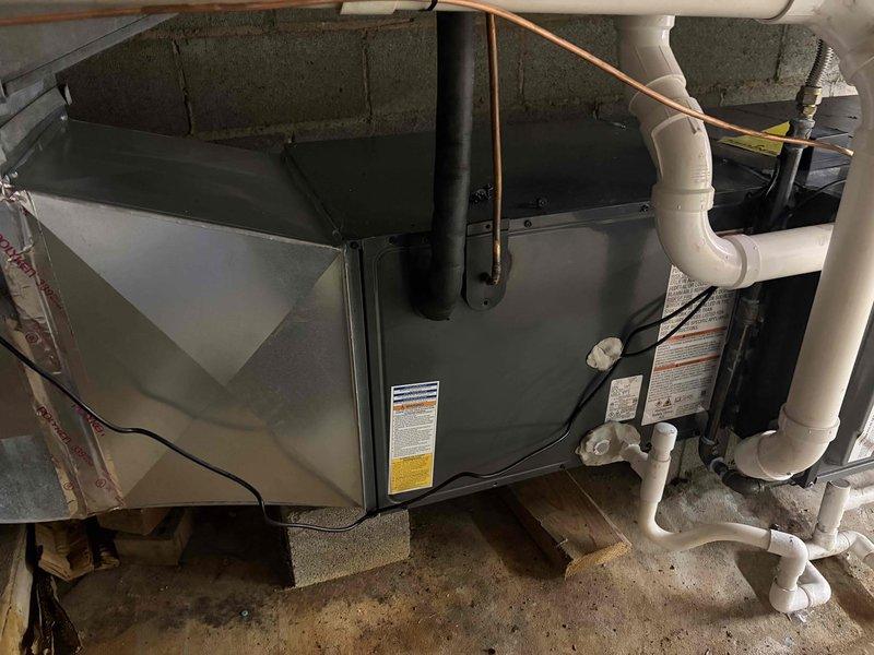 Completed installation of new air conditioning system including outdoor condensing unit and indoor air handler. Connected refrigerant lines, electrical wiring, and condensate drainage with proper insulation and secure mounting on concrete pad with leveling blocks. System tested and verified operational with all components functioning within manufacturer specifications.