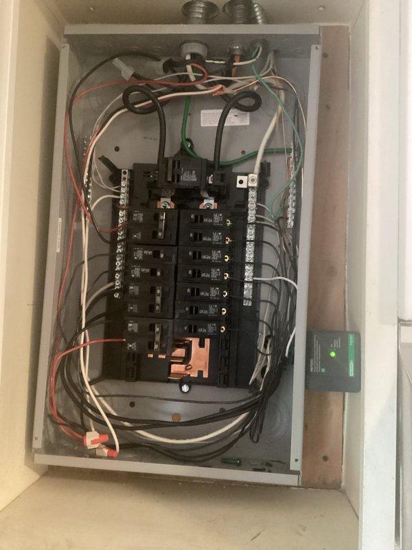 Completed electrical panel inspection and smoke detector installation/replacement. Verified proper circuit breaker operation, wire connections, and panel organization with appropriate neutral and ground terminations on bus bars. Installed new smoke detector on wall with functional indicator light and proper mounting near ceiling junction.