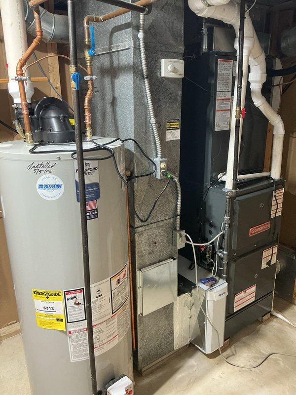 Completed routine cooling system maintenance on residential HVAC unit. Inspected dual pleated air filters showing moderate dust accumulation, examined Goodman furnace system and associated components including water heater, condensate drainage lines, and electrical connections to ensure proper operation ahead of cooling season.