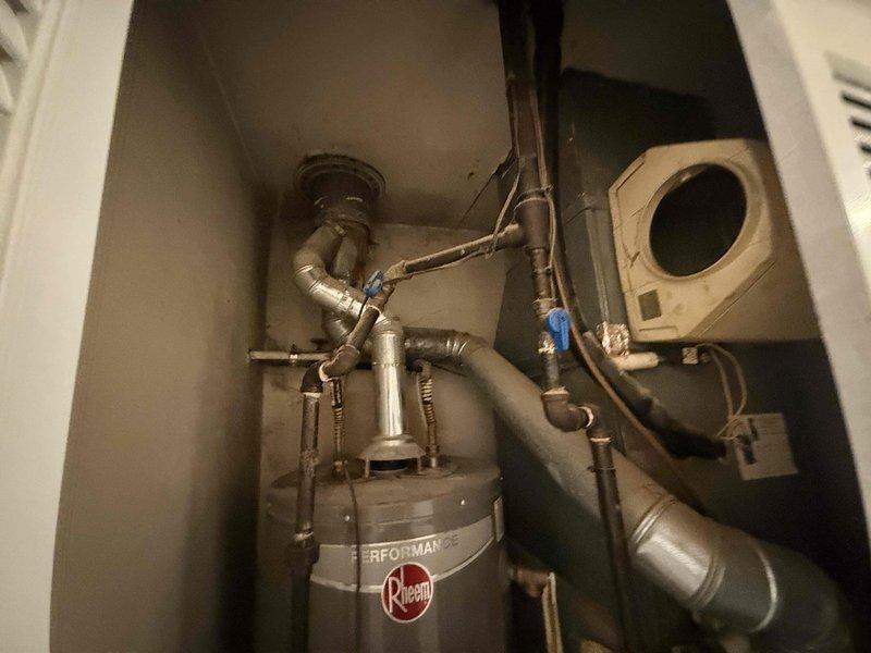 Responded to service call for AC system leaking heavily in basement during operation. Upon arrival, inspected HVAC equipment and drainage system in utility closet. Identified compromised condensate drain pan as source of water leak. Assessed wall damage in adjacent hallway caused by water infiltration from failed drainage system. Documented equipment condition and leak damage with photographs. Discussed repair versus replacement options with customer based on extent of drain pan failure and resulting water damage to surrounding structure.