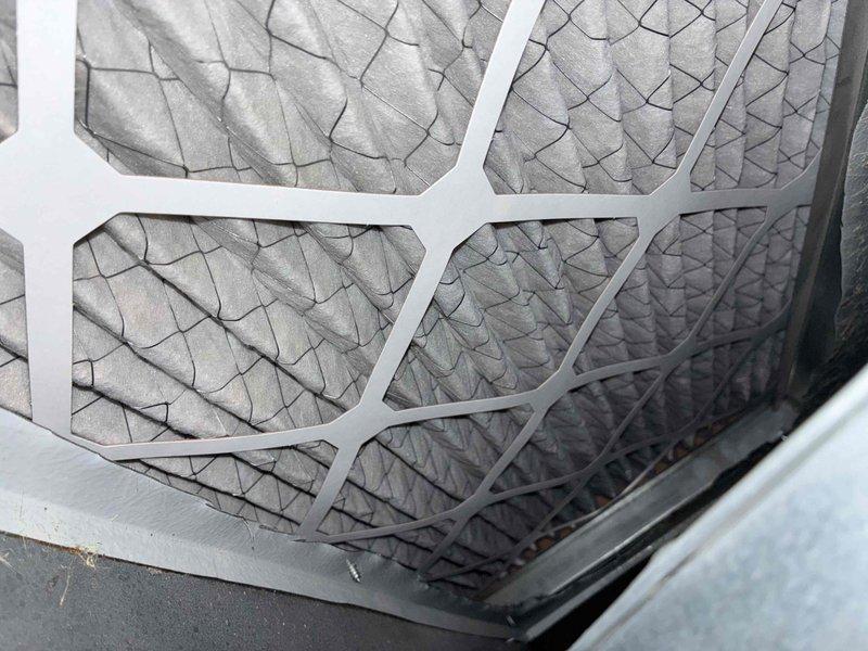 Performed routine cooling system maintenance on residential HVAC unit. Inspected outdoor condenser unit, refrigerant lines, and electrical connections, confirming all components operational. Evaluated air filter condition in return air housing, noting accumulated dust and debris from normal operation, with filter media showing adequate airflow capacity for continued use.