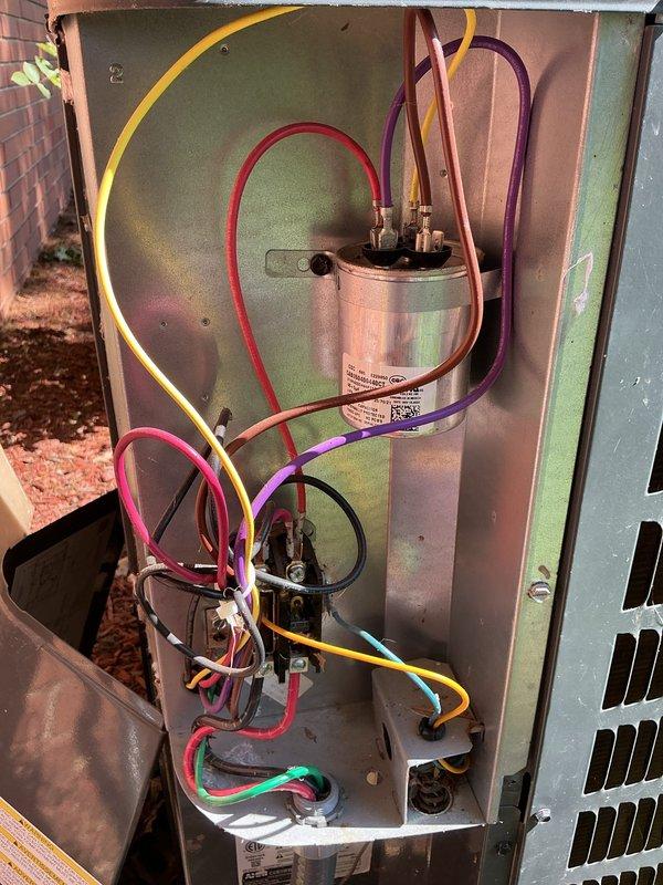 Performed comprehensive cooling system maintenance on residential outdoor condensing unit. Inspected condenser coils, which showed moderate oxidation and weathering consistent with unit age, confirmed proper airflow clearance, and verified refrigerant line insulation integrity. Removed access panel to inspect electrical components including dual capacitors, confirmed all wire connections secure at terminals, and verified proper operation of internal mechanical systems.