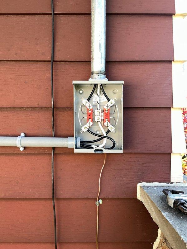Completed installation of 100 amp exterior electrical service upgrade. Installed new ground rod with proper burial depth in lawn area, mounted weatherproof junction box on exterior wall with appropriate conduit connections, and established proper grounding connections per NEC standards.