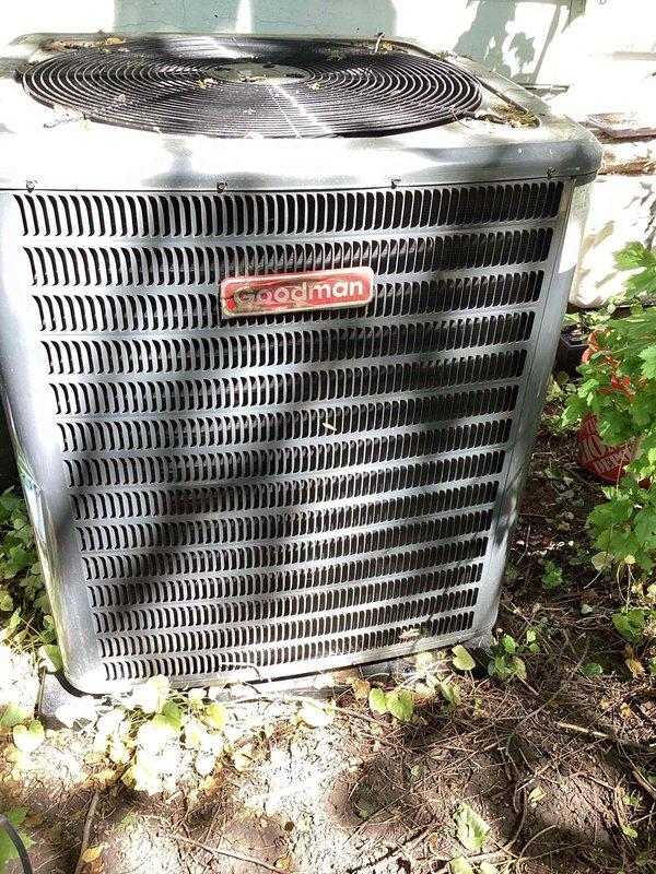 Performed comprehensive cooling system maintenance on Goodman brand outdoor condensing unit. Inspected condenser coils, fan assembly, and electrical components for proper operation. Unit found to be in functional condition with normal outdoor weathering present on exterior surfaces.
