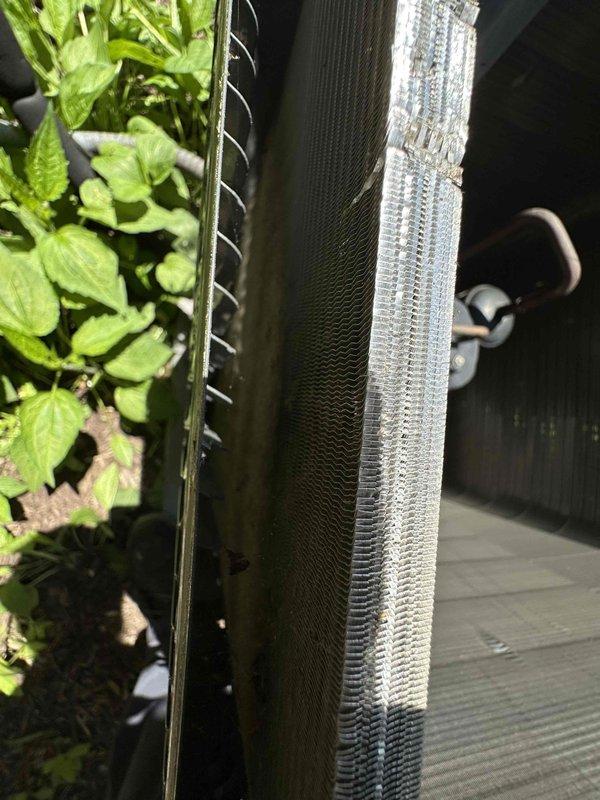 Completed scheduled preventive maintenance on two cooling systems. Inspected condenser coils and found vegetation growth near unit fins, which was addressed to ensure proper airflow and heat exchange efficiency. Performed electrical measurements using clamp meter to verify system amperage draw and operational parameters, confirming both units are operating within manufacturer specifications.