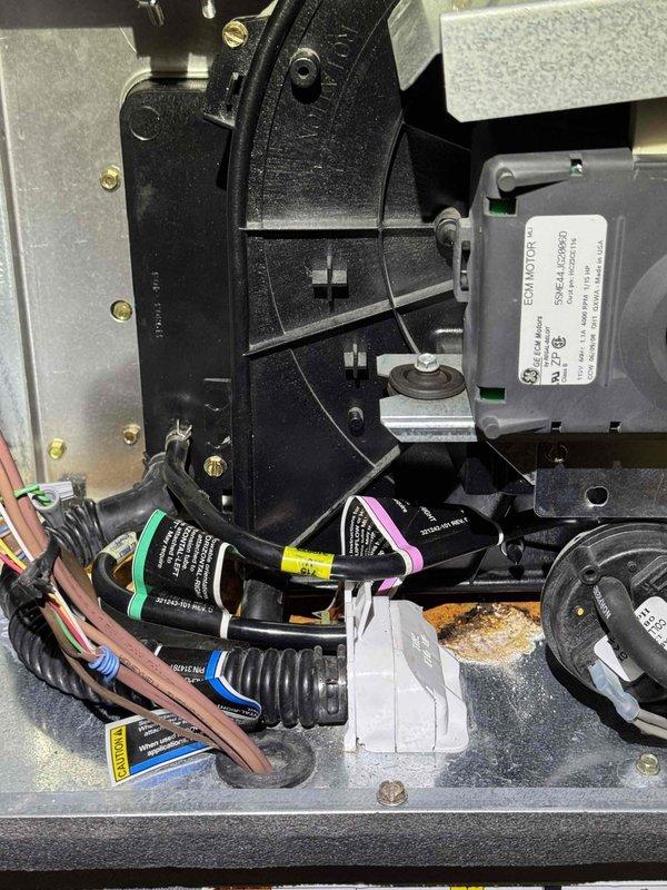 # HVAC Cooling System Tune-Up

Performed comprehensive cooling system maintenance and inspection on residential HVAC unit. Accessed interior compartments to evaluate blower motor assembly, electrical control modules, and wiring harnesses. All electrical connections were inspected and found secure with proper cable management and protective sheathing in place. Control relays and modules showed appropriate labeling for maintenance reference.

Inspection revealed moisture intrusion evidence with rust-colored staining and mineral deposits on metal surfaces within the unit, indicating potential condensate drainage concerns. Documented existing condition of affected areas. Blower motor housing and cylindrical refrigerant line connections were examined and secured with proper mounting brackets and fasteners. All mechanical components showed normal wear consistent with regular operation.

System operational check confirmed proper function of cooling components. Recommended monitoring for addit
