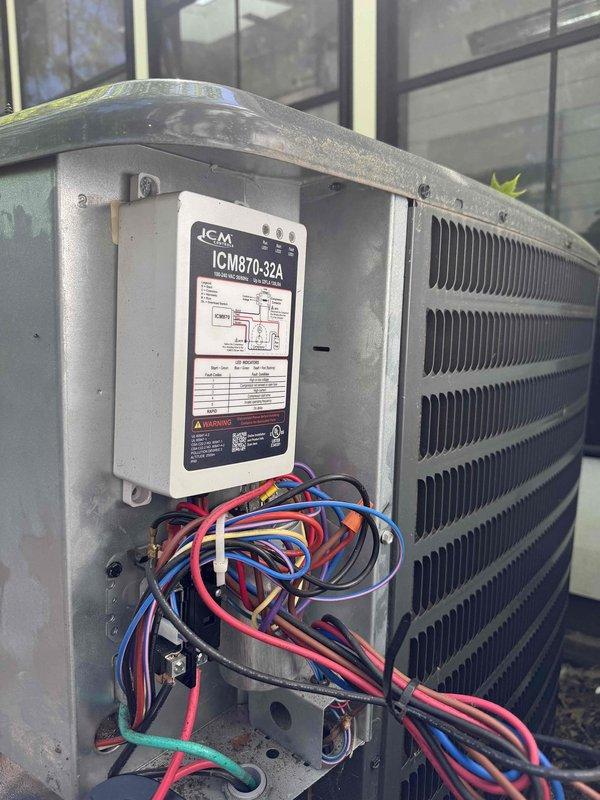 Responded to service call for air conditioning unit making unusual noise and experiencing extended cooling times. Upon arrival, performed diagnostic evaluation of outdoor condenser unit. Inspected ICM870-32A control module and associated electrical connections, noting multiple wiring connections to the system. Utilized digital clamp meter to measure electrical current and voltage readings, obtaining measurements of 381.4 volts to assess compressor and system performance. Evaluated condenser unit operation, including examination of exterior components and control box functionality to identify source of reported noise concern and cooling inefficiency.