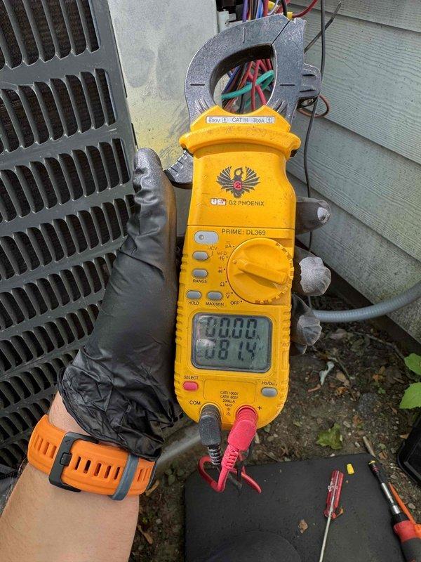 Responded to service call for air conditioning unit making unusual noise and experiencing extended cooling times. Upon arrival, performed diagnostic evaluation of outdoor condenser unit. Inspected ICM870-32A control module and associated electrical connections, noting multiple wiring connections to the system. Utilized digital clamp meter to measure electrical current and voltage readings, obtaining measurements of 381.4 volts to assess compressor and system performance. Evaluated condenser unit operation, including examination of exterior components and control box functionality to identify source of reported noise concern and cooling inefficiency.