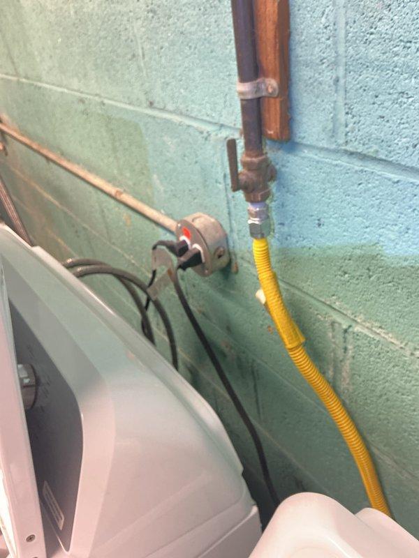 Completed electrical inspection of residential utility area, accessing property through rear entrance as requested. Documented electrical panel installation with dual-row circuit breaker configuration, verified proper wire management and secured connections at main terminal block. Inspected utility room mechanical connections including gas shut-off valve, CSST flexible gas connector line, and copper piping installations mounted to cinder block wall. All photographed components showed standard residential utility configurations with appropriate safety installations.