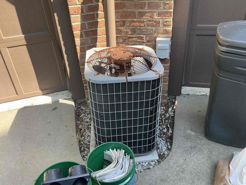 Conducted HVAC equipment assessment for system replacement at condo unit with easy accessibility. Evaluated existing thermostat wiring configuration with properly connected Y, C, W, G, R, and OB terminals, and inspected outdoor condenser unit positioned on concrete pad with decorative rock surround against brick wall exterior. Documented current equipment conditions and provided replacement options for complete system upgrade.
