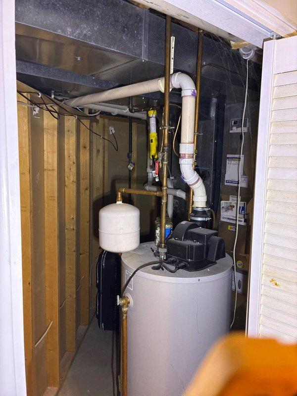 Conducted on-site assessment of existing HVAC system and water heating equipment located in utility closet. Evaluated current configuration including water heater, expansion tank, PVC and copper piping connections, and ductwork arrangement. Documented equipment layout and measured available space, noting 9-foot clearance for replacement unit installation. Provided customer with equipment replacement options and specifications for system upgrade.