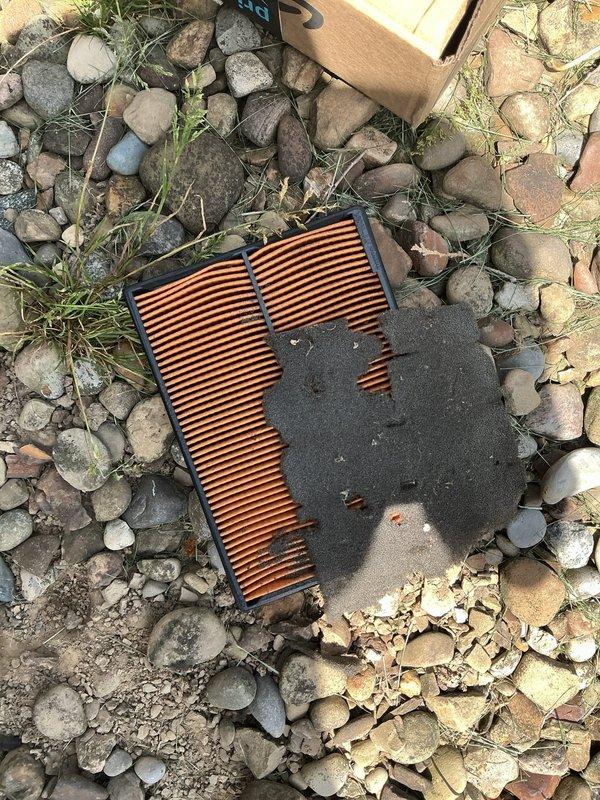 Performed scheduled generator maintenance including inspection of critical components and air filtration system. Cleaned heavily soiled air filter showing significant dust and debris accumulation, and verified proper operation of suspension-mounted generator assembly with associated electrical connections and wiring harnesses intact.
