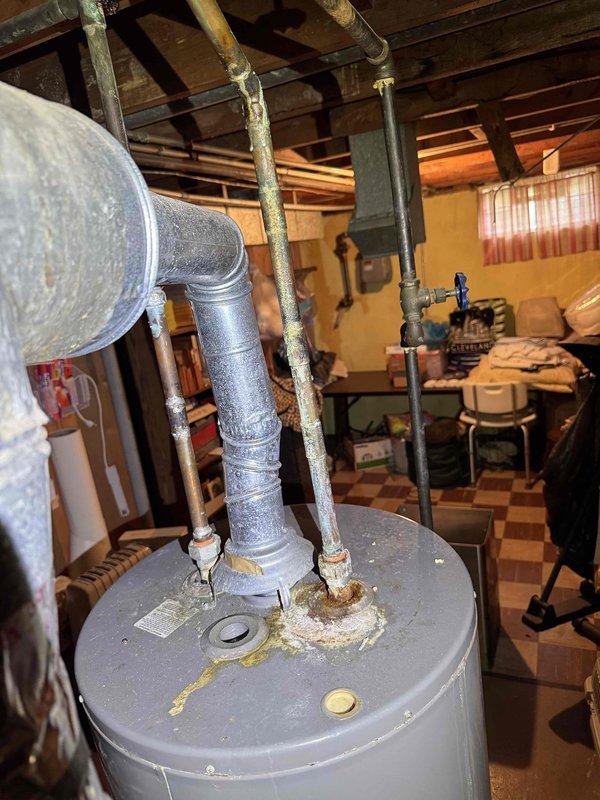 # HVAC Cooling Maintenance Service

Completed comprehensive cooling system maintenance as part of recurring preventive service plan. Performed standard inspection of air conditioning equipment located in basement utility area, including examination of condensate drainage system and associated components.

Inspected condensate drain pan and pump assembly, noting accumulation of mineral deposits, sediment buildup, and water staining on pan surfaces. Observed oxidation on copper refrigerant lines and aging of piping connections at water heater and HVAC equipment. Verified condensate pump operation and drainage functionality. Documented equipment condition through photographic records showing drain pan interior with central pump mechanism, connecting pipes, and electrical wiring connections.

Assessed overall system accessibility in basement mechanical room with stored items present. All cooling system components inspected and found operational for continued service.
