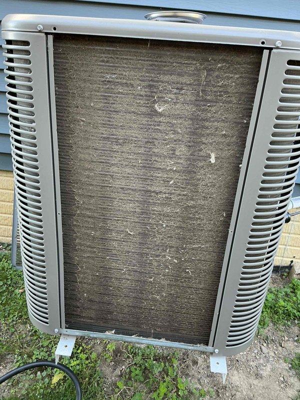 Completed scheduled preventive maintenance on residential split-system air conditioning unit. Upon arrival, outdoor condenser unit exhibited heavy accumulation of dirt, dust, and debris on intake surfaces and coil fins, which significantly restricts airflow and reduces system efficiency. Performed thorough cleaning of condenser coils using appropriate methods to remove fibrous buildup and restore proper heat exchange capability. Cleared debris from around unit perimeter and verified proper clearances for adequate ventilation. Inspected refrigerant lines, electrical connections, and mounting hardware for secure installation and proper condition. Unit operational and running within normal parameters upon completion of maintenance service.