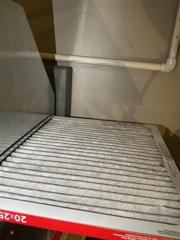# HVAC Cooling Maintenance Summary

Completed routine preventive maintenance on residential air conditioning system. Inspected air handler unit, noting 20x25 air filter with moderate dust accumulation requiring replacement. Examined outdoor condensing unit electrical connections at disconnect box, verifying proper terminal connections and copper bus bar integrity. All components operating within normal parameters upon completion of maintenance visit.

---

## Detailed Service Report

Performed comprehensive cooling season maintenance on residential HVAC system as part of ongoing preventive maintenance program. 

**Indoor Unit Service:**
Accessed air handler unit and inspected 20x25 pleated air filter mounted in return air plenum. Filter exhibited moderate dust loading consistent with normal usage patterns. Examined ductwork connections and foam insulation seals at panel joints for proper fit and condition. Verified PVC condensate drain line routing and secure mounting. Inspected metal 