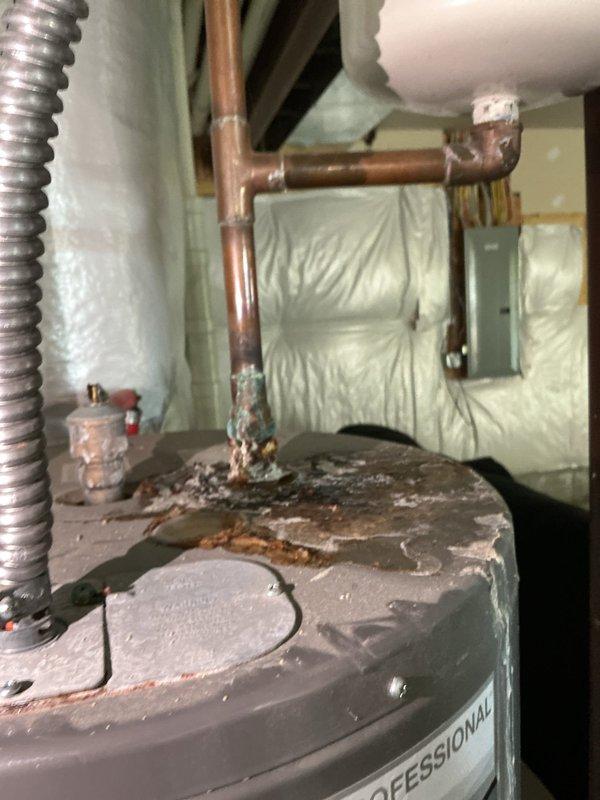 Responded to service call for furnace making extremely loud noise. Upon arrival, inspection revealed the photos captured were of a water heater rather than the furnace system. Water heater exhibited significant rust and corrosion on top surface around pipe connections, with deteriorated condition of unit noted. No furnace service was documented or performed during this visit.