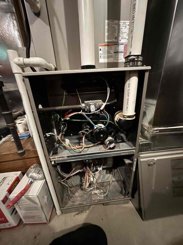 # HVAC Cooling System Maintenance

Performed comprehensive cooling system maintenance on residential HVAC unit. Conducted thorough inspection of furnace and air handler assembly with front access panel removed to evaluate internal components, blower motor operation, and electrical connections. All wiring harnesses, including control wires and sensor connections, were inspected and found to be properly secured.

Identified significant frost accumulation on evaporator coil surface during inspection, indicating potential airflow restriction or refrigerant charge issue. Used digital temperature measurement device to assess coil temperatures and verify system performance. The heavy crystallization pattern observed on the coil suggested restricted airflow or possible low refrigerant charge affecting heat exchange efficiency.

Examined blower assembly, ductwork connections, and condensate drainage system including PVC drain lines. Verified proper installation and routing of refrigerant lines 