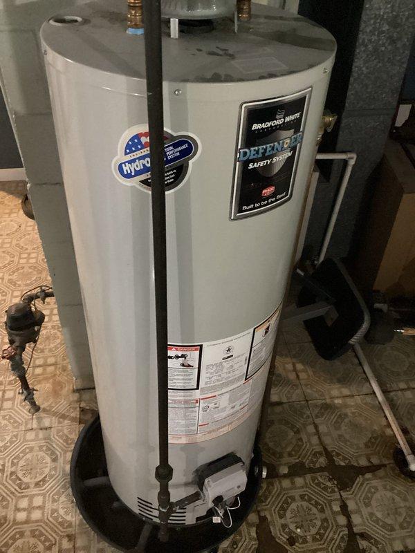 Responded to service call for Bradford White Defender Safety System tanked water heater reported as not working correctly. Upon arrival, performed visual inspection of unit and surrounding installation. Assessed water heater condition, verified proper installation of copper supply lines and brass fittings at top connections, and examined ventilation components at base of unit. Documented equipment specifications and current state of system for service records.