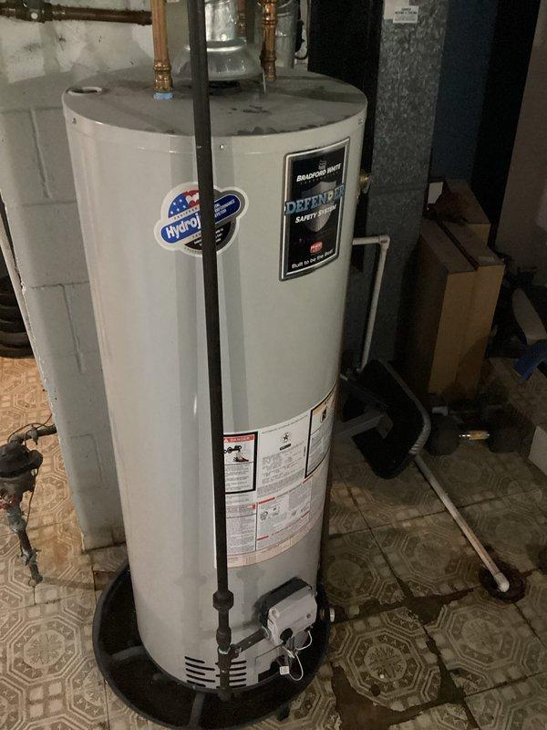 Responded to service call for Bradford White Defender Safety System tanked water heater reported as not working correctly. Upon arrival, performed visual inspection of unit and surrounding installation. Assessed water heater condition, verified proper installation of copper supply lines and brass fittings at top connections, and examined ventilation components at base of unit. Documented equipment specifications and current state of system for service records.