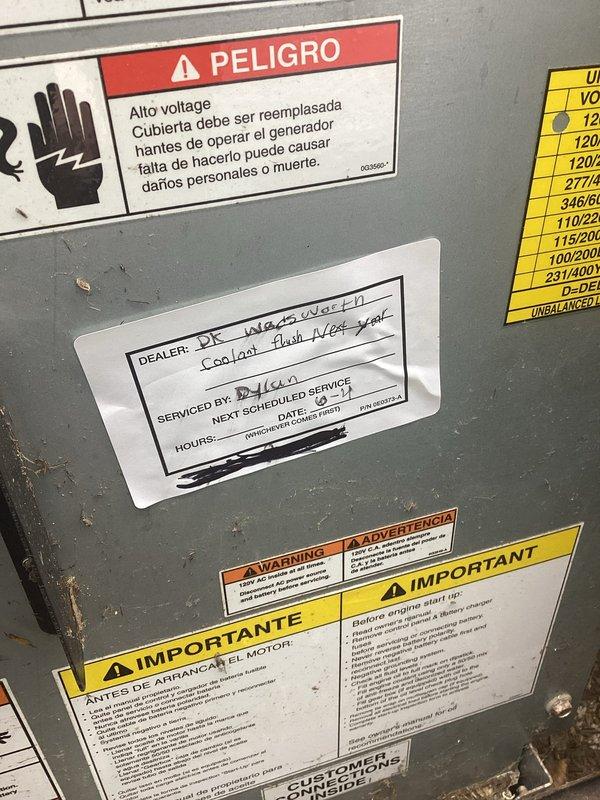 Performed scheduled maintenance on commercial generator system. Inspected internal components including compressor unit, refrigerant lines, and electrical connections. Verified all warning labels and safety documentation were properly displayed and legible on equipment exterior panel.