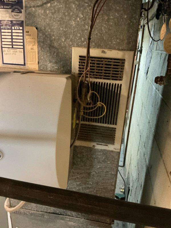 Responded to service call for residential air conditioning system found to be completely flat on refrigerant. Upon inspection, determined that the existing HVAC equipment, including both the indoor air handler and outdoor condensing unit, are original to the home and have reached the end of their serviceable life expectancy. Evaluated the electrical service panel and existing equipment configuration in the basement utility area. Provided comprehensive replacement options to the homeowner, including system sizing recommendations and equipment specifications appropriate for the application. Documented existing conditions with photographs of the current air handler unit showing copper refrigerant lines and the electrical breaker panel with circuit identification. Recommended full system replacement due to age of equipment and loss of refrigerant charge, as repair would not be cost-effective given the overall condition and age of the components.