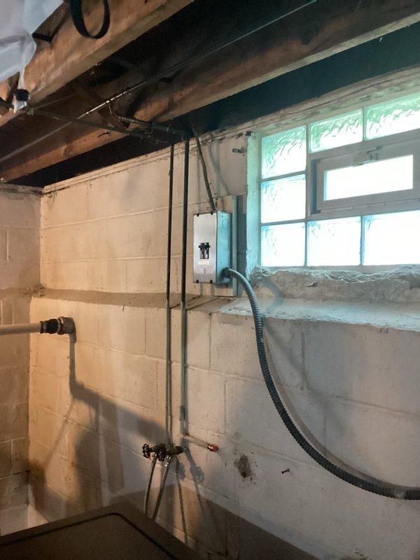 Completed comprehensive electrical inspection of residential property with focus on basement utility areas and main electrical panel. Assessed existing electrical system including circuit breaker panel with handwritten circuit identification labels, evaluated grounding requirements for multiple outlets throughout the residence, and identified need for outlet relocation. Documented requirement for new GFCI-protected outlet installation in bathroom to meet current code standards. Evaluated laundry area where appliance is currently powered by extension cord and determined need for dedicated 120V circuit and properly grounded receptacle for washing machine to eliminate safety hazard and ensure code compliance.