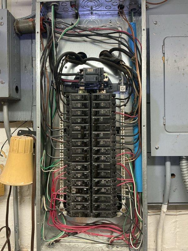 Completed comprehensive electrical inspection of residential system. Documented main electrical panel configuration showing dual-row circuit breaker arrangement with proper bus bar connections and multiple active circuits serving various building loads. Photographed water heater installation with associated electrical connections and verified proper wiring configuration to mechanical equipment.