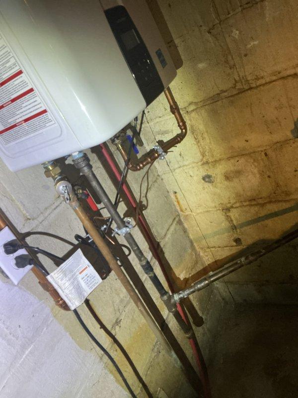Completed comprehensive electrical inspection of residential system. Documented main electrical panel configuration showing dual-row circuit breaker arrangement with proper bus bar connections and multiple active circuits serving various building loads. Photographed water heater installation with associated electrical connections and verified proper wiring configuration to mechanical equipment.