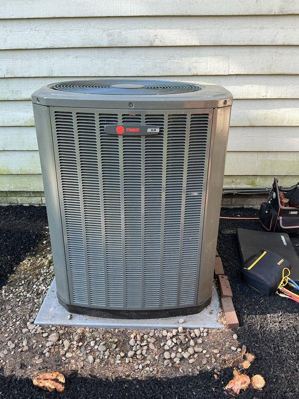 # HVAC Cooling Maintenance Completed

Performed comprehensive cooling system maintenance on a Trane XL outdoor condensing unit. Conducted thorough inspection revealing significant biological growth and environmental weathering on exterior panels, along with corrosion on refrigerant line connections and base components. Cleaned condenser coils, checked refrigerant pressures, verified electrical connections, and ensured proper airflow through all grilles and fan assembly, restoring system to optimal operating condition.