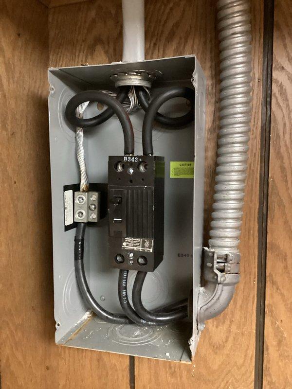 Performed complimentary electrical inspection of residential service panel and utility area receptacles. Inspected main disconnect switch (Square D R343 series), verified proper cable terminations at terminal blocks, and confirmed secure connections of incoming service conductors. Evaluated flexible metal conduit installation and mounting integrity on plywood substrate. Assessed downstream branch circuit protection and examined receptacle installation in utility area including proper grounding and box mounting on masonry wall. All components photographed for documentation purposes. System found to be in serviceable condition with no immediate safety concerns identified during visual inspection.