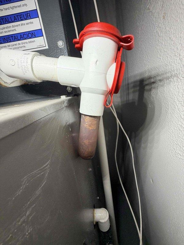 Responded to no cooling call on aging HVAC system. Upon arrival, confirmed unit was running but not producing cool air. Opened air handler access panel to inspect internal components, checked electrical connections, blower motor assembly, and wiring. Examined refrigerant lines, condensate drain system with PVC T-junction and copper drain extension, and verified proper drainage function. Documented system condition with photos showing air handler configuration, ductwork connections, and drainage components for service records.
