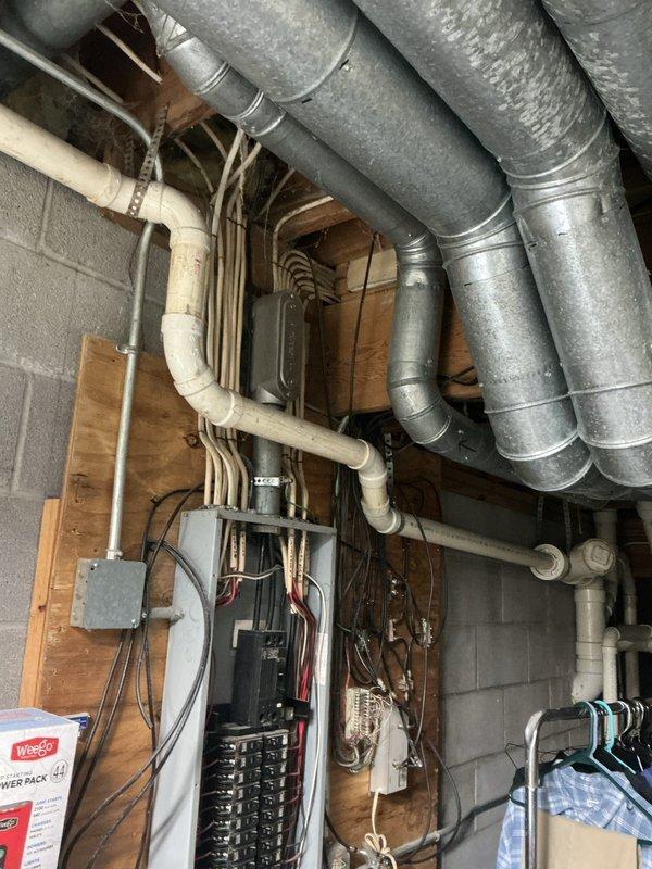 Performed comprehensive electrical inspection of residential utility area and workshop space. Documented existing electrical panel installations, circuit breaker configurations, and conduit routing for compliance verification. Photographed electrical infrastructure including main service panels, copper wiring connections, and protective conduit systems to establish baseline condition assessment of the electrical distribution system.
