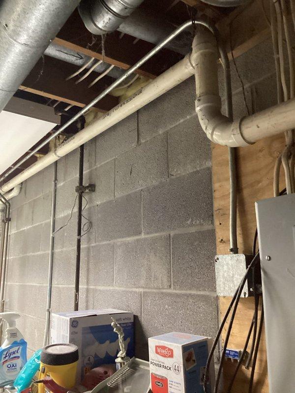 Completed comprehensive plumbing inspection of residential basement utility area. Documented all visible plumbing systems including PVC drainage lines, supply piping, and connections along exposed ceiling joists and concrete block walls, verifying proper installation and identifying no immediate concerns requiring corrective action.