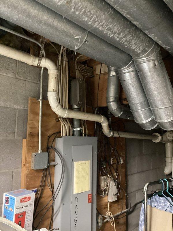 Completed comprehensive plumbing inspection of residential basement utility area. Documented all visible plumbing systems including PVC drainage lines, supply piping, and connections along exposed ceiling joists and concrete block walls, verifying proper installation and identifying no immediate concerns requiring corrective action.
