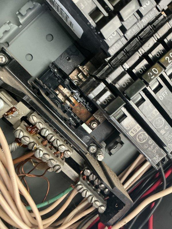Performed comprehensive electrical inspection of main service panel and associated equipment. Documented panel configuration showing proper circuit breaker installation with visible amperage ratings, verified neutral and ground bus bar connections with multiple conductor terminations, and noted presence of surge protection device. Observed minor discoloration on central bus bar connections indicating normal operational wear. Inspected secondary equipment revealing rust staining on metal brackets and components requiring monitoring for potential corrosion progression.