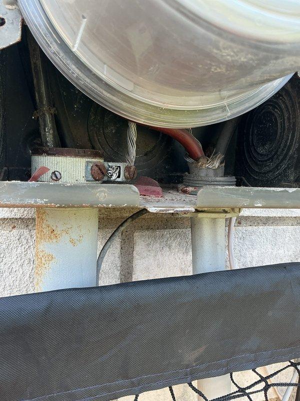 Performed comprehensive electrical inspection of main service panel and associated equipment. Documented panel configuration showing proper circuit breaker installation with visible amperage ratings, verified neutral and ground bus bar connections with multiple conductor terminations, and noted presence of surge protection device. Observed minor discoloration on central bus bar connections indicating normal operational wear. Inspected secondary equipment revealing rust staining on metal brackets and components requiring monitoring for potential corrosion progression.