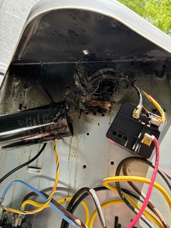 Responded to no cooling complaint two days after routine maintenance. Upon inspection, discovered severe electrical failure in outdoor unit with catastrophic capacitor failure and fire damage to control compartment. Interior of electrical housing showed extensive burn marks, soot deposits, and charred components with melted material throughout upper section of compartment. Verified voltage readings at 110.5V and measured system parameters. Equipment sustained significant electrical damage requiring component replacement to restore cooling operation.