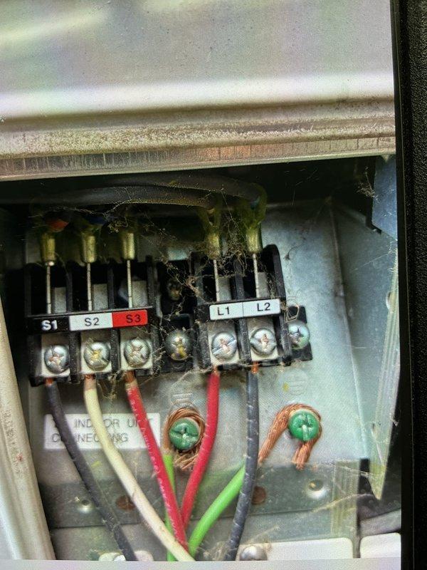 Responded to no cooling complaint for commercial office mini split system. Upon inspection, discovered severe electrical failure in the indoor unit's junction box with evidence of arcing, overheating, and burnt wiring at the terminal connections. Found charred insulation and melted debris throughout the electrical compartment, indicating a significant electrical fault had occurred. Assessed the damage to terminal blocks labeled S1, S2, S3, L1, and L2, along with compromised wire connections. Documented the electrical damage and verified the system was inoperable due to the failure. Collected service fee and provided photographic documentation of the electrical fault for repair estimate purposes.