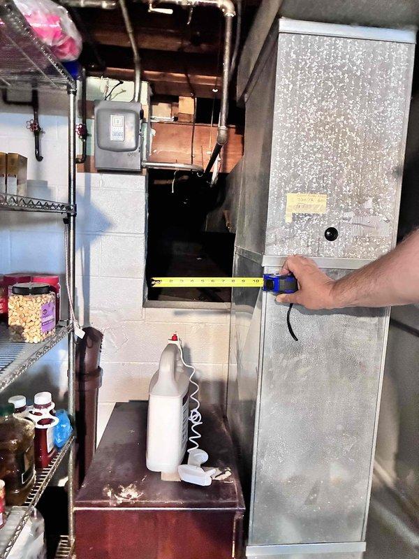 Conducted HVAC system replacement estimate at rental property with easy access to equipment located in basement utility area. Assessed existing gray metal furnace cabinet and associated electrical disconnect components, documented current system configuration and measurements for replacement specifications. Provided equipment replacement options to property owner for existing HVAC system serving the residence.
