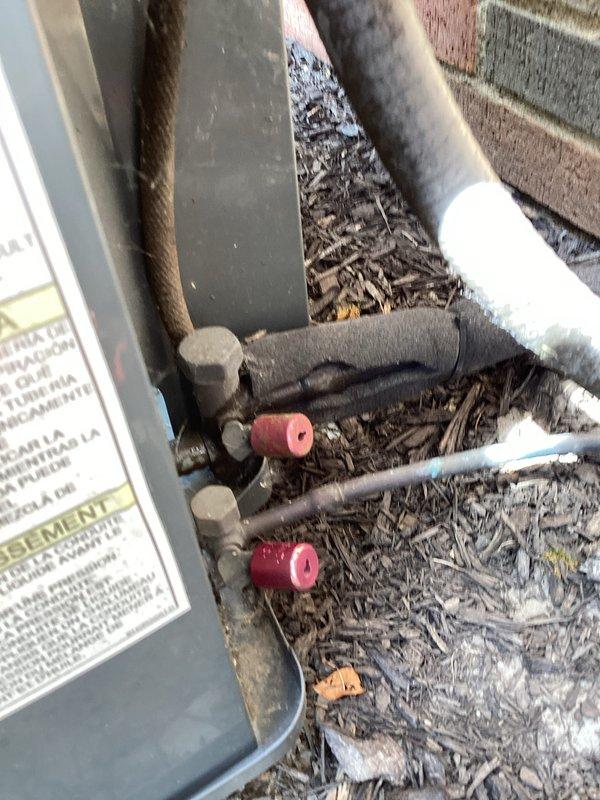 Completed scheduled cooling system maintenance on residential HVAC unit. Replaced air filter and thermostat batteries as needed. Verified system operation with temperature readings showing proper cooling performance at 51.9°F at the evaporator coil. Inspected outdoor condensing unit, confirmed refrigerant line connections secure with service port caps in place, and noted minor debris accumulation around equipment base that does not impact system function.