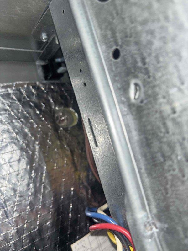 Completed scheduled preventive maintenance service on window-mounted HVAC cooling system. Performed comprehensive system inspection including examination of air filter, ductwork connections, and electrical components. Filter showed moderate dust and debris accumulation consistent with normal operation; documented current condition with photographs for maintenance records. Verified proper installation of pleated air filter within metal housing frame and confirmed secure mounting. Inspected internal ductwork insulation, metal framework, and control wiring including power and control circuits. All electrical connections, including blue, red, and yellow control wires, were found to be properly secured and routed. System components, ductwork, and access panels were in satisfactory operating condition with no immediate service needs identified.